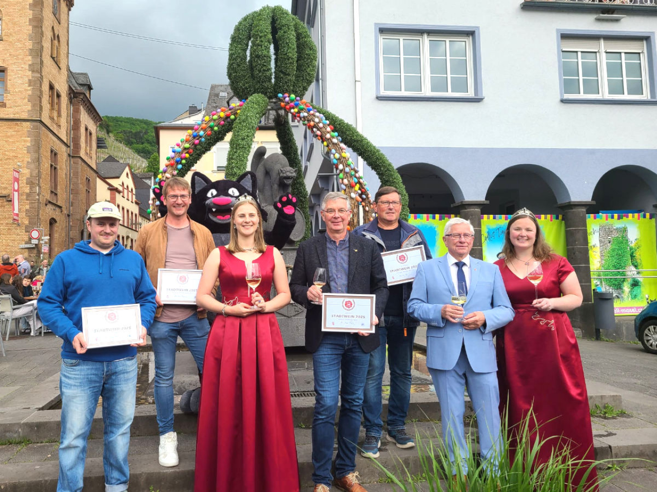 Die vier Gewinner bei der Wahl zum Stadtwein 2025 mit Bürgermeister und Weinmajestäten von Zell.